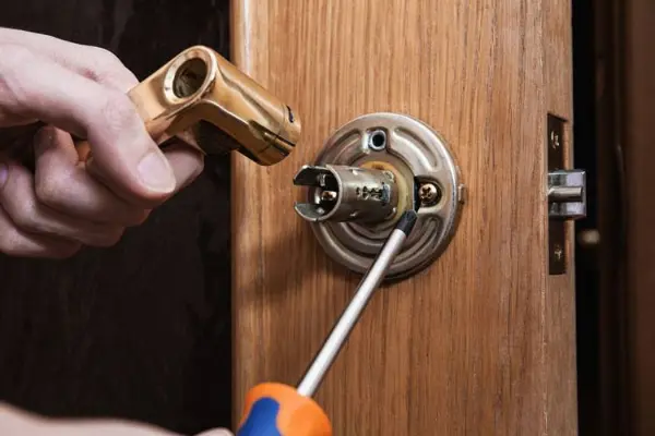 local locksmith working on a door knob handle